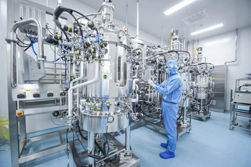 Yunhon technician in cleanroom suit at stainless production equipment